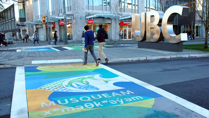 The Musqueam logo is painted on the sidewalk at Wesbrook Mall and University Boulevard