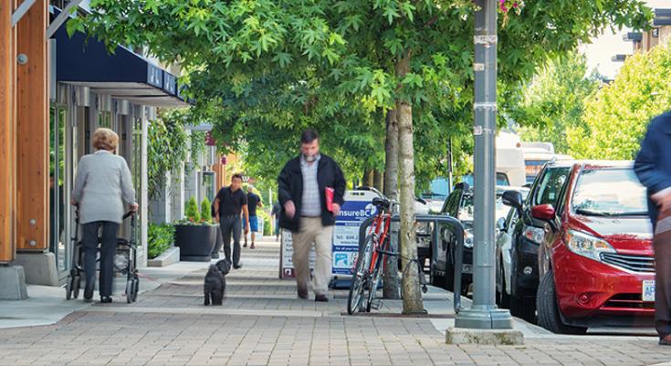 Residents walk on sidewalk in Wesbrook Village