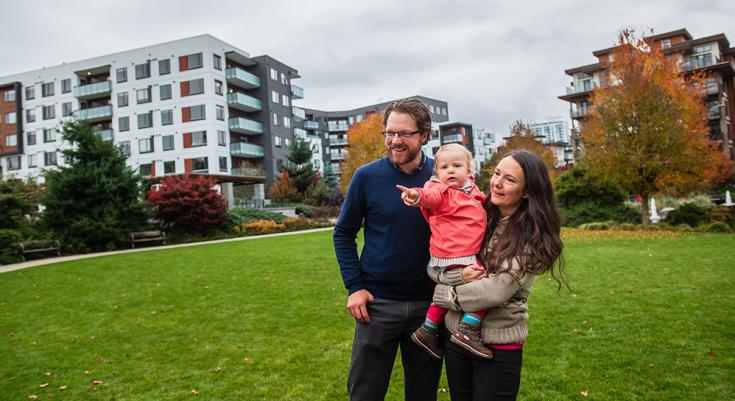 Selfy, her husband, and her toddler standing on the grass looking at one direction