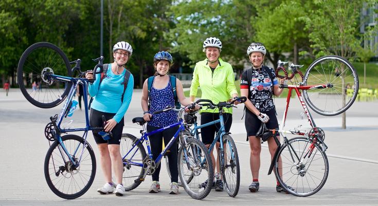 Four people holding up bikes as part of Go By Bike Week.