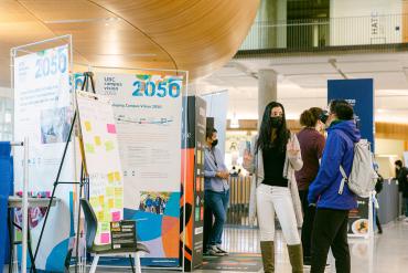 Staff talking to students at a Campus Vision 2050 pop-up informational booth.