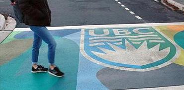 A student crosses the street at Wesbrook Mall and University Boulevard