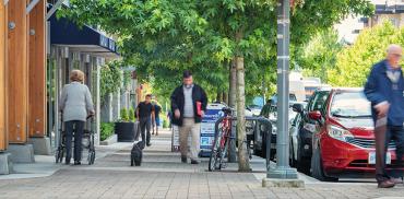 Residents walk on sidewalk in Wesbrook Village